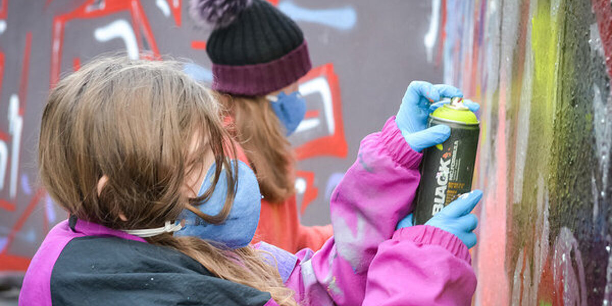 Kinder sprühen Graffiti